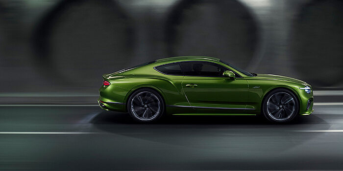  Bentley Leusden Bentley Continental GT coupe in Tourmaline Green paint driving in profile on a dark road