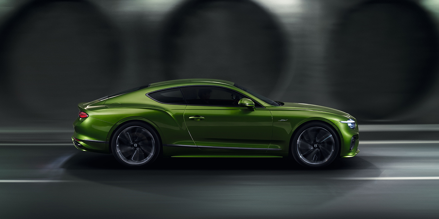 Bentley Leusden Bentley Continental GT coupe in Tourmaline Green paint driving in profile on a dark road